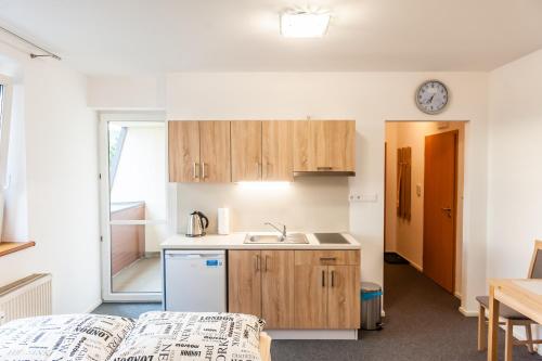 a kitchen with wooden cabinets and a sink at Apartmány Summit in Bešeňová