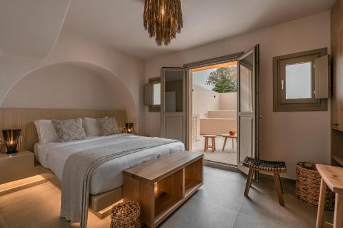 a bedroom with a bed and a room with a table at Living Moments in Fira