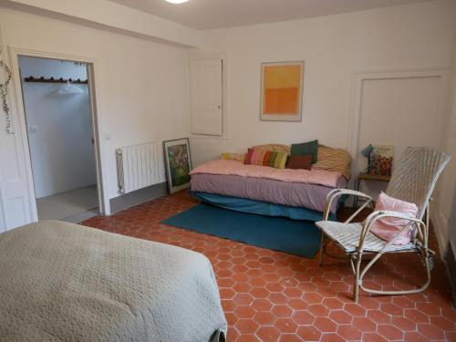 une chambre avec un lit et une chaise dedans dans l'établissement La Ferme de Victor - Maison de village, à Coussegrey