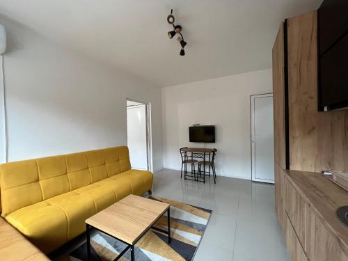 sala de estar con sofá amarillo y mesa en Apartment Monaliza, en Pirot