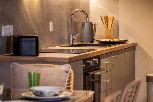 フィスカルドにあるSeaside ground floor elegant Suite in Fiskardo! 20 steps from Zavalata beach!のシンクとコンロのあるキッチン