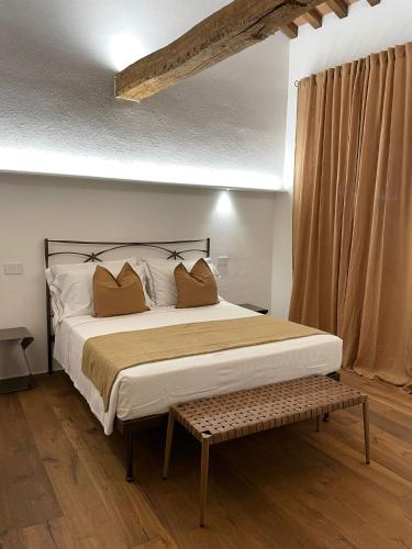 a bed with two pillows and a bench in a room at MontepulcianoLettings in Montepulciano