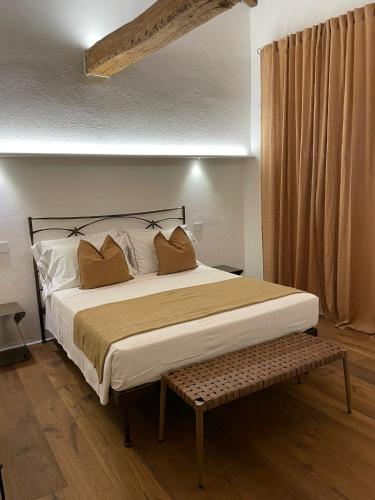 a bedroom with a large bed with a bench next to it at MontepulcianoLettings in Montepulciano