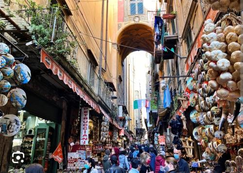 a crowd of people walking through a street with shops at Casa Nonna Rusell in Naples