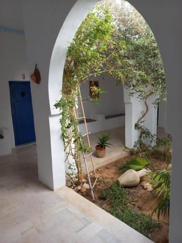 an archway with trees and plants in a room at villa la rose des sables in Midoun
