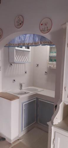 baño blanco con lavabo y ventana en Casina del castello, en Castelnuovo della Misericordia