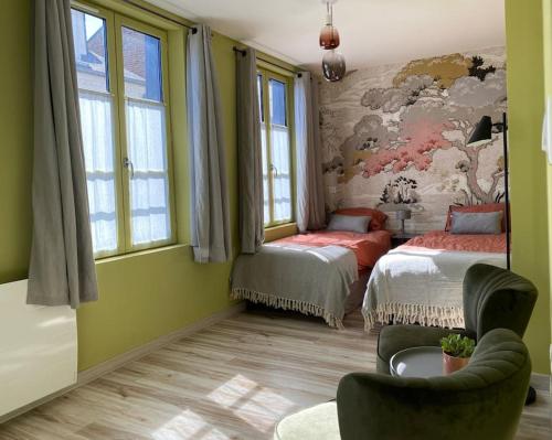 Cette chambre comprend deux lits et un tableau mural. dans l'établissement Luminieuse maison de pêcheur avec terrasse, à Saint-Valery-sur-Somme