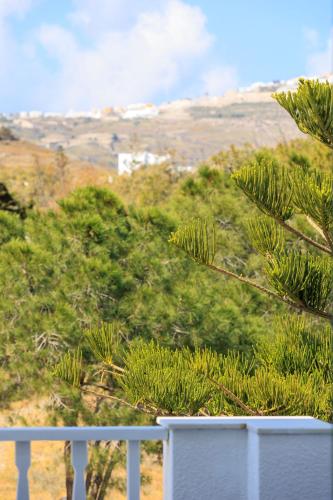 a balcony with a white fence and trees at Aerno Home & Azul Ηοme - Ahilli Slow Living in Kamari