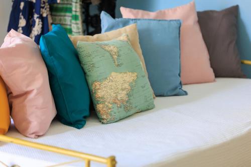 a couch with colorful pillows on it at Aerno Home & Azul Ηοme - Ahilli Slow Living in Kamari
