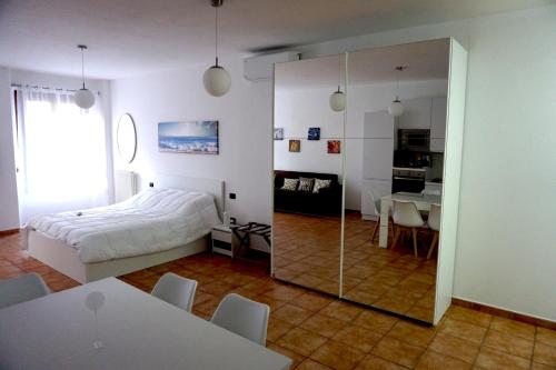 um quarto com uma cama, uma mesa e um espelho em A CASA CAVOUR Apartment RIMINI CENTER Teatro Galli em Rimini