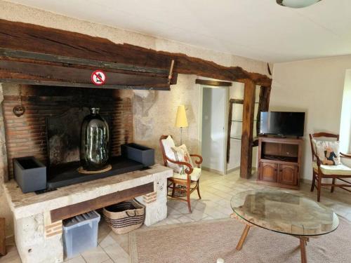 - un salon avec une cheminée et une table dans l'établissement Le P'tit Beine, à Mont-près-Chambord