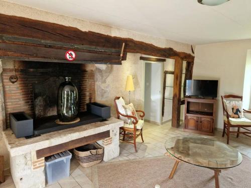 a living room with a fireplace and a table at Le P'tit Beine in Mont-près-Chambord