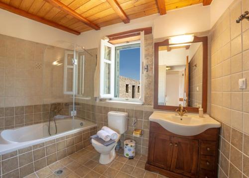 ein Badezimmer mit einem Waschbecken, einem WC und einer Badewanne in der Unterkunft THEO in Alexandros