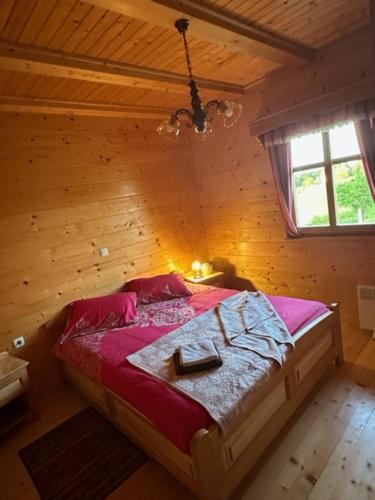 um quarto com uma cama num quarto de madeira em Wooden house em Šmarje pri Jelšah