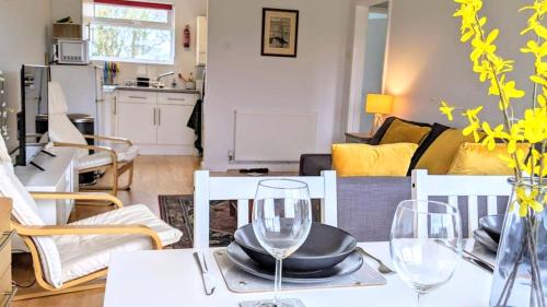 una mesa de comedor con dos copas de vino encima en Comfortable bungalow near Widemouth Bay beach, en Poundstock
