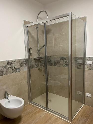 a shower with a glass door next to a sink at Il Bosco Incantato in Borgo San Dalmazzo