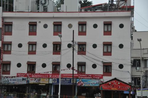 a large white building with black circles on it at JC Woodville Manor in Kodaikānāl