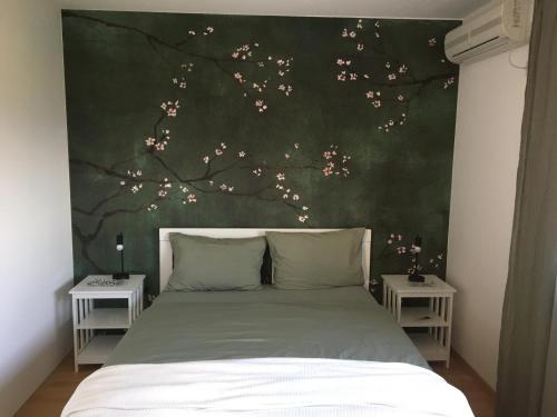 a bedroom with a bed with a tree mural at Apartment Jasmina in Krimovice