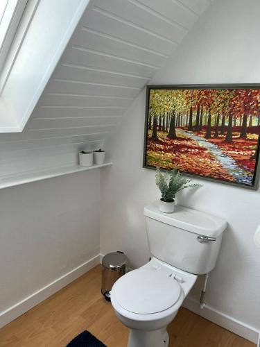 a bathroom with a toilet with a painting on the wall at River View City Centre- Free Parking in Inverness
