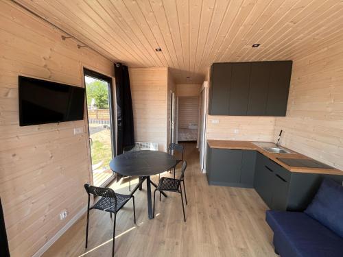 a small kitchen and dining area of a tiny house at Domki Letniskowe Rewa in Rewa