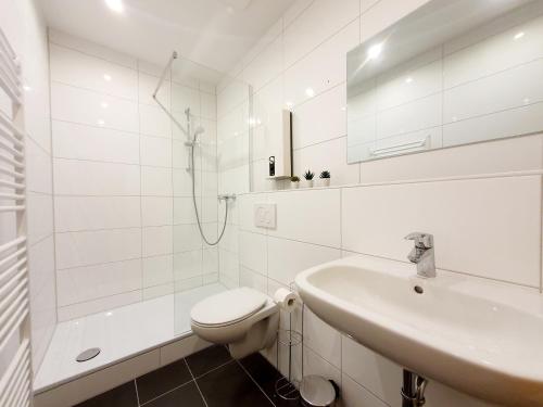 een witte badkamer met een toilet en een wastafel bij Stadtmensch Oberhausen 3 Schlafzimmer in Oberhausen