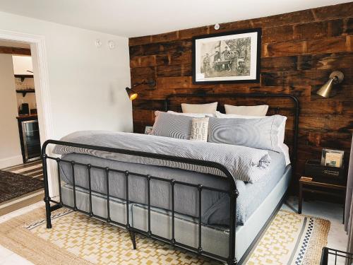 1 dormitorio con 1 cama con pared de madera en Wm. Farmer and Sons en Hudson