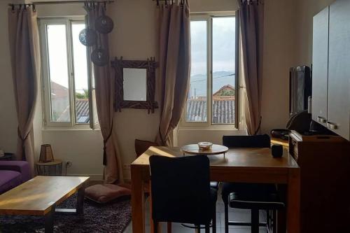 un salon avec une table, des chaises et des fenêtres dans l'établissement Appartement T2 en bord de mer, à Marseille