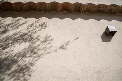 a shadow of a tree on the side of a building at B&B La Manica in Milazzo