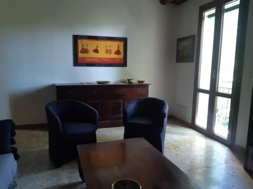 ein Wohnzimmer mit 2 Stühlen und einem Tisch in der Unterkunft La casa dell' Agave in Caltanissetta