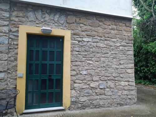 a stone building with a green door on it at La casa dell' Agave in Caltanissetta