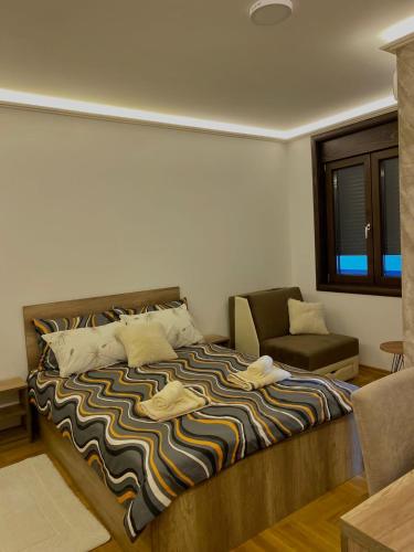 a bedroom with a bed and a chair and a window at Studio Rilak in Vrnjačka Banja