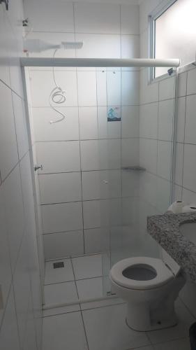 a white bathroom with a toilet and a shower at Hotel Barão Ribeirão in Ribeirão Preto