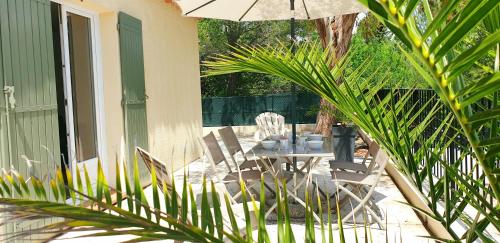 a patio with a table and chairs and an umbrella at Une maison en Provence in Pierrevert