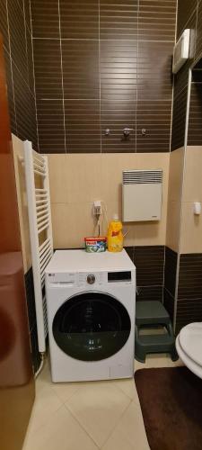 uma pequena cozinha com uma máquina de lavar louça branca na casa de banho em Apartment A&E Bjelasnica em Bjelašnica