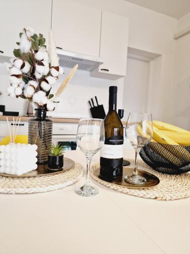 Apartment Melani في فير: زجاجة من النبيذ وكأسين من النبيذ على منضدة