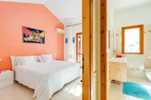 1 dormitorio con cama blanca y baño en Villa Bellavista IS MOLAS PULA, CAGLIARI en Santa Margherita di Pula
