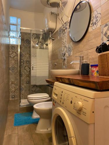 a bathroom with a toilet and a sink and a washing machine at In The Heart Of Naples in Naples