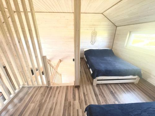 a bedroom with a bed in a wooden cabin at BALTICO Domki Letniskowe in Sarbinowo