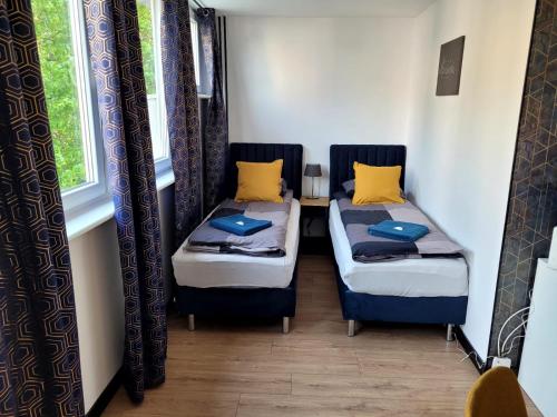 two beds in a room with two windows at Szczecin Centrum 3 in Szczecin