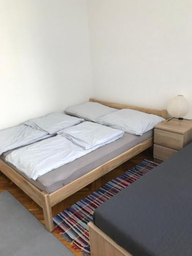 a bedroom with a bed and a nightstand next to it at Központi apartman in Kiskunfélegyháza