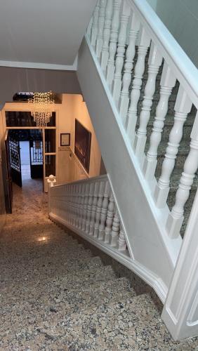 a staircase in a house with a white stair case at Rif Appartment in Al Hoceïma