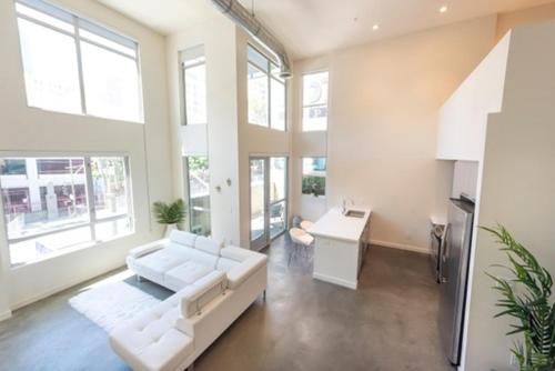 - un salon avec un canapé blanc et une table dans l'établissement 1500 Sq foot, 3 bed room loft in DTLA (Pool & Hot tub!), à Los Angeles