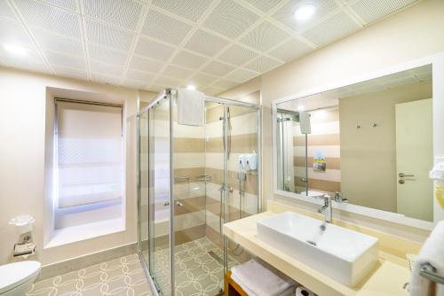 a bathroom with a sink and a shower at Ulusoy Kemer Holiday Club - Kids Concept in Kemer