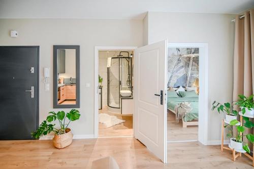 een kamer met een deur en potplanten bij Apartamenty Warzywna in Leszno
