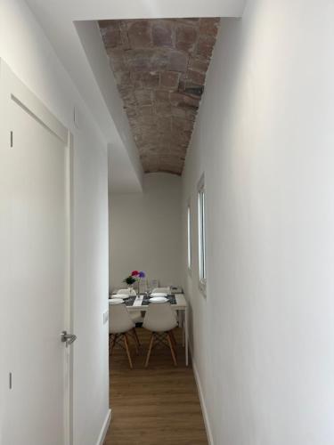 una sala da pranzo con tavolo e pareti bianche di Apartamento Kemacu a Barcellona