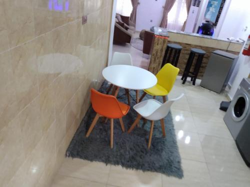 a table and four chairs in a room at Exquisite and Cozy 3-bedroom Apt with hot-tub, WiFi, DSTV, and Inverter Power Backup in Agege