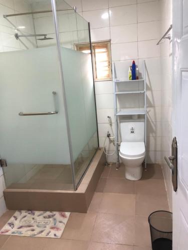 a bathroom with a shower and a toilet at Exquisite and Cozy 3-bedroom Apt with hot-tub and WiFi in Agege