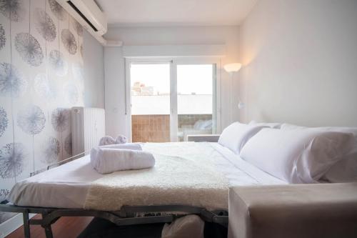 a white bedroom with a bed and a window at For Your Rentals Coqueto apartamento cerca al Parque Retiro GPA92 in Madrid