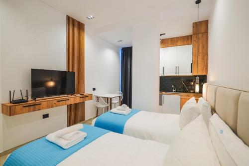 een hotelkamer met 2 bedden en een flatscreen-tv bij JAD rooms in Sarandë