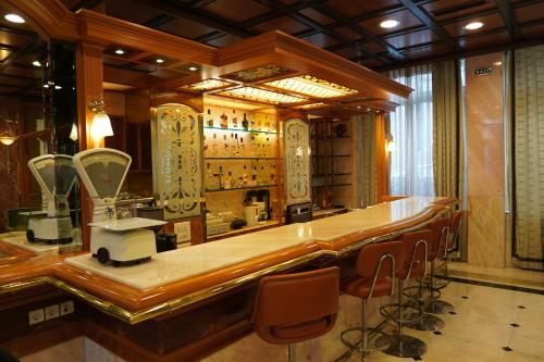 a bar in a salon with a counter and chairs at Balasca Hotel in Athens